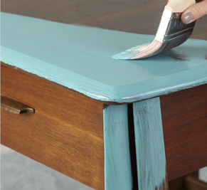 Person painting a coffee table with light blue paint