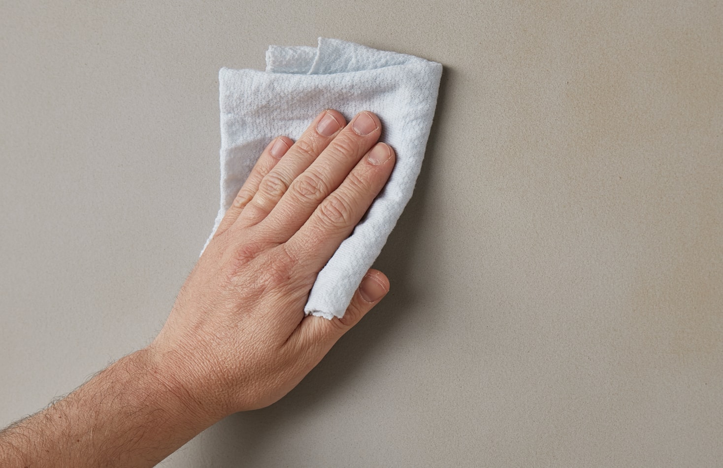 Wiping down walls with damp cloth
