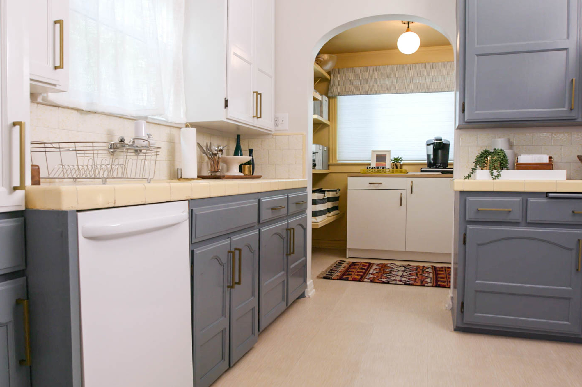 Kitchen with blue lower cabinets and white upper cabinets with white appliances