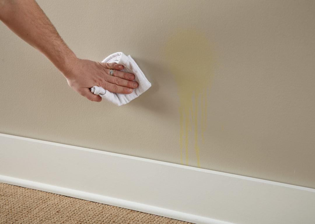 Person trying to wipe a stain on the wall off