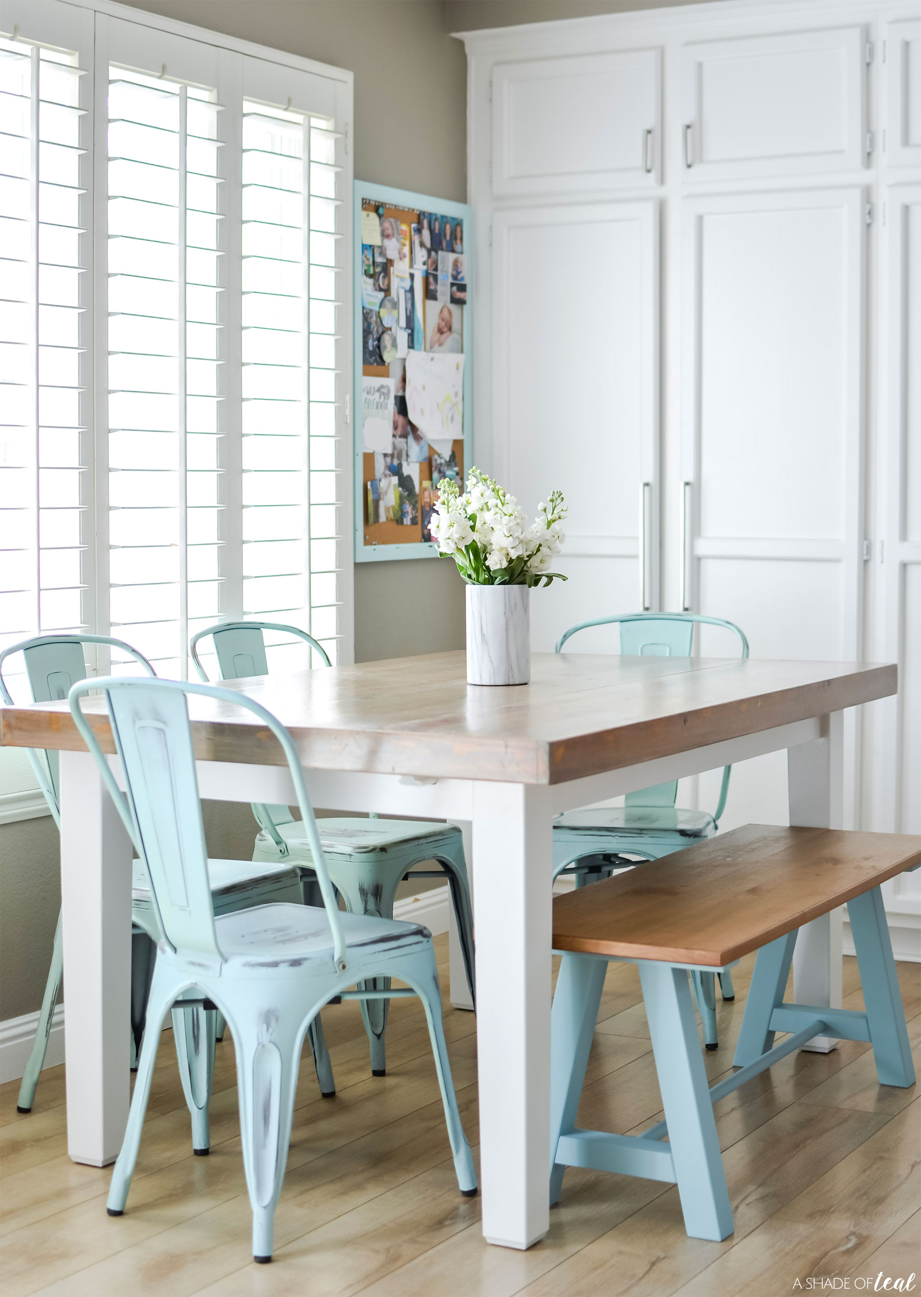 Wooden dining room table with light teal chairs