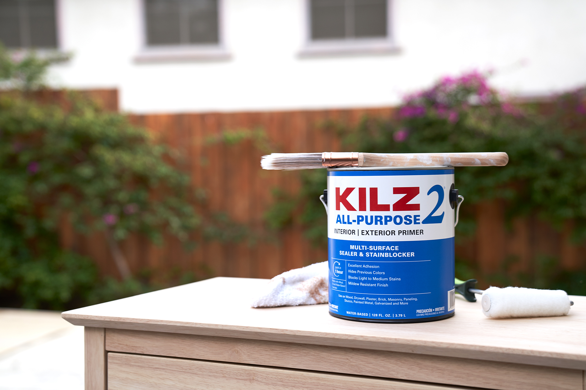 Main image of KILZ 2 All-Purpose Primer with a paint brush on top of a 1-gallon can in a backyard.