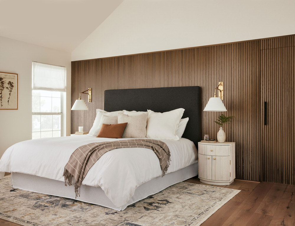 Side image of primary bedroom with wood stained wall using Magnolia Home by Joanna Gaines® interior stain Woodsy Escape. 