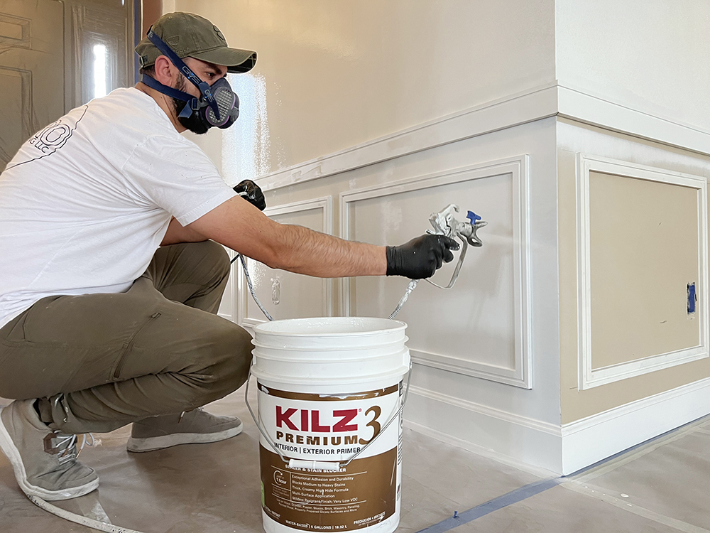 Image of Klaudio spraying KILZ 3 Premium primer on wall
