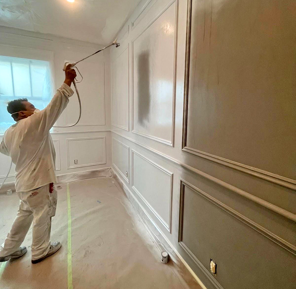 Image painter spraying KILZ 2® All-Purpose primer onto office walls