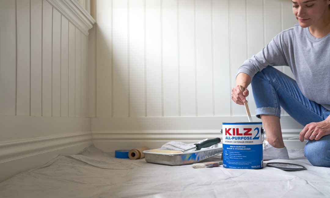 Image of individual stirring KILZ 2 All- Purpose primer before project.