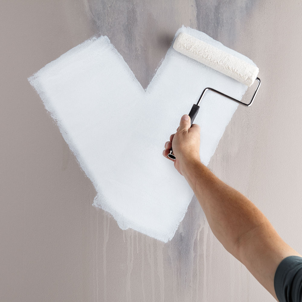 Image of individual applying primer to a wall.