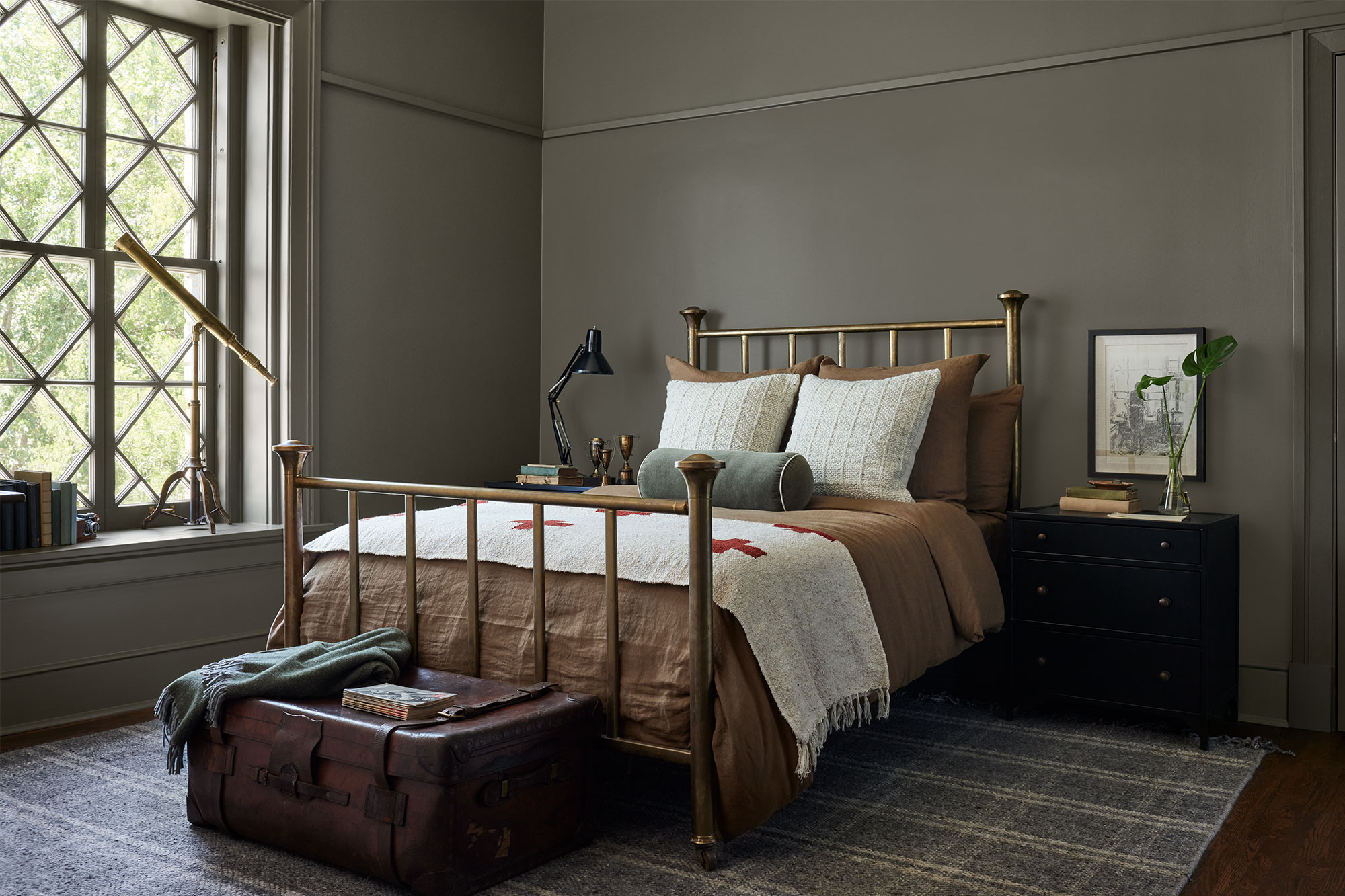 Bedroom with gold bed frame and brown bedding. Dark and masculine decor accents. Dark Green/Gray wall paint.
