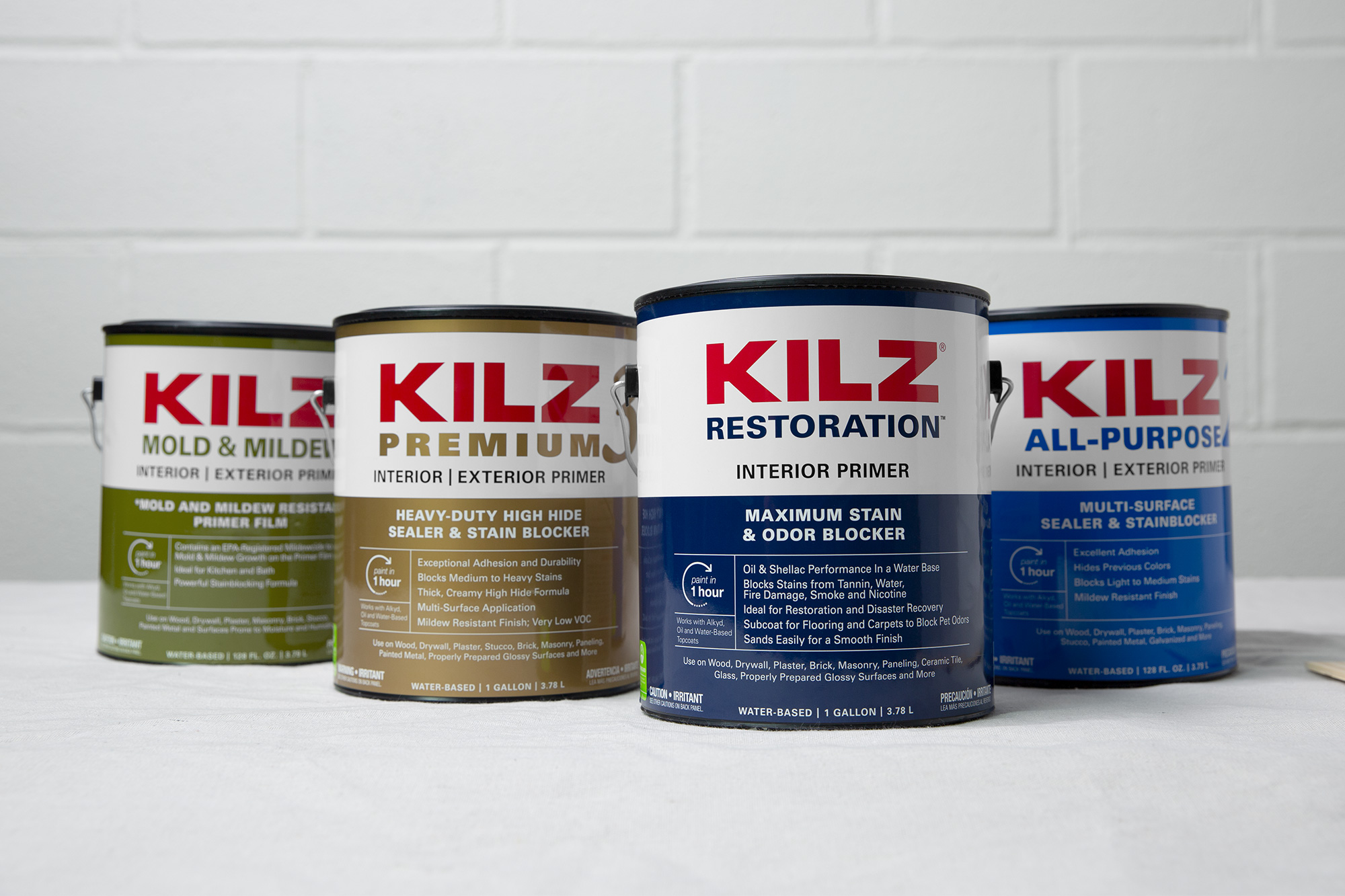 Cans of KILZ Primers lined up in a row in front of a white wall.