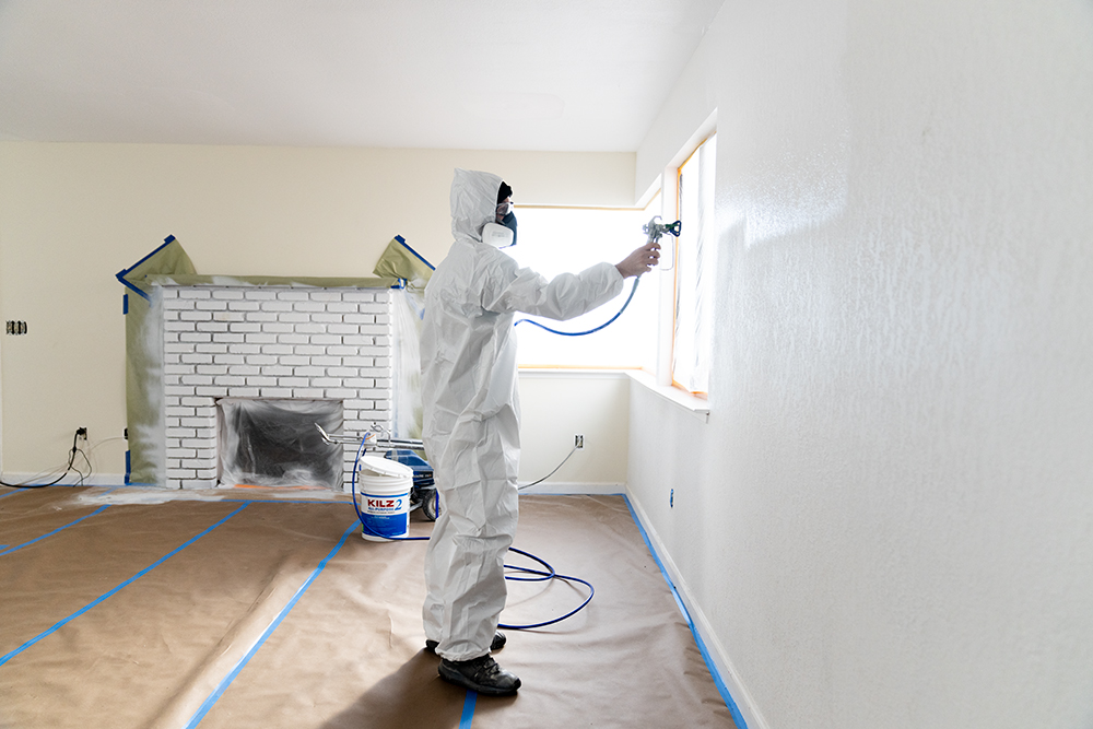 Image of a PRO painter applying KILZ 2 All Purpose Primer to a wall using a spray painter