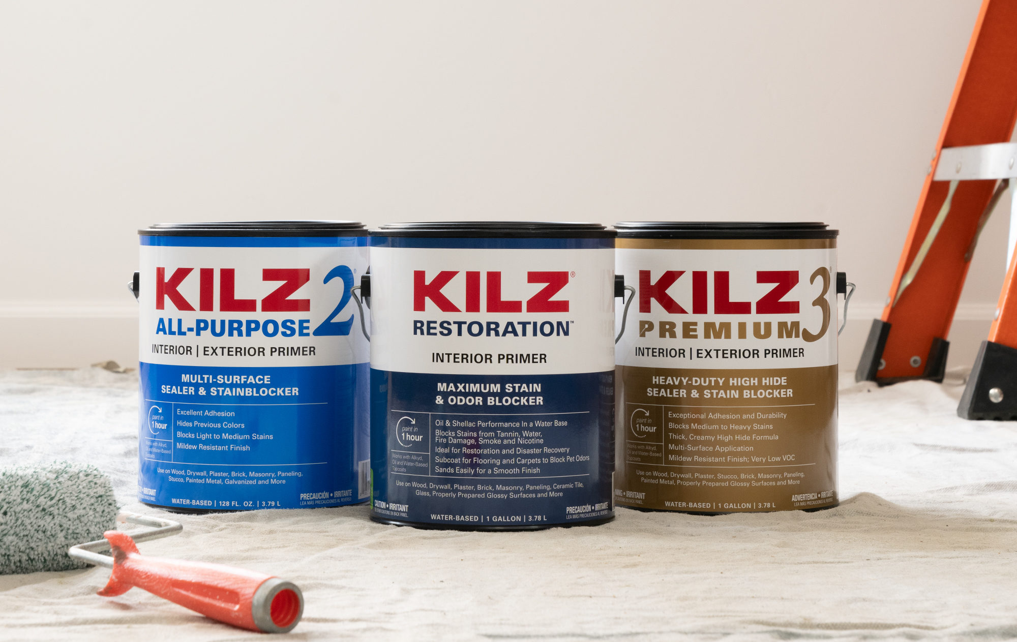 Close up shot of KILZ 2 All Purpose Primer, KILZ Restoration, and KILZ 3 Premium 1-gallon cans with paint roller laid next to it