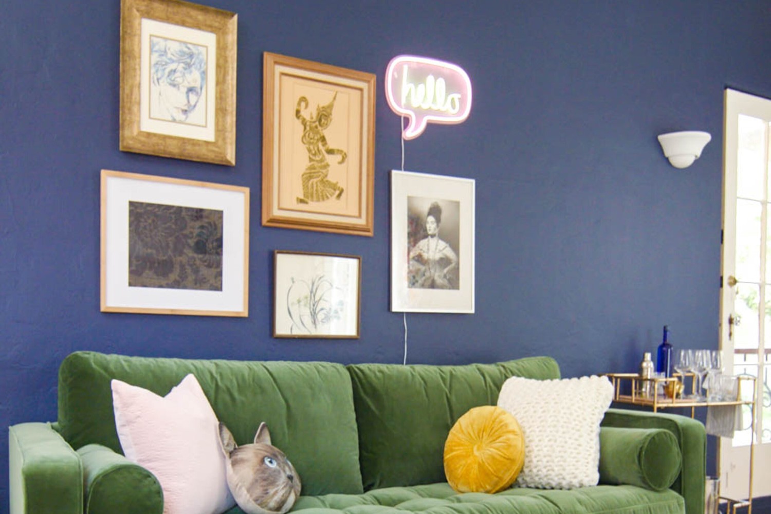 Blue gallery wall with green couch