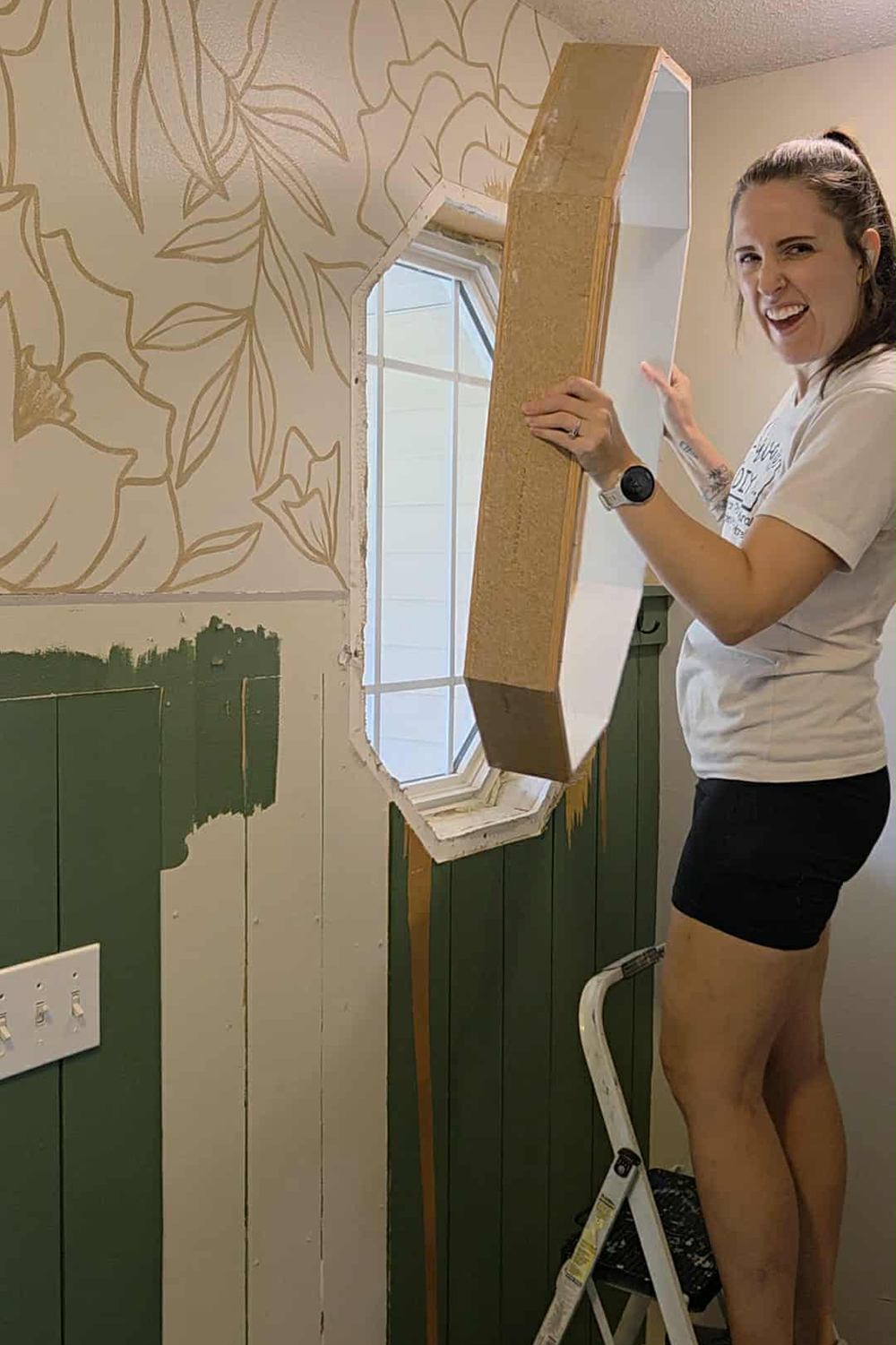 Sarah Berg removing a window from the wall.
